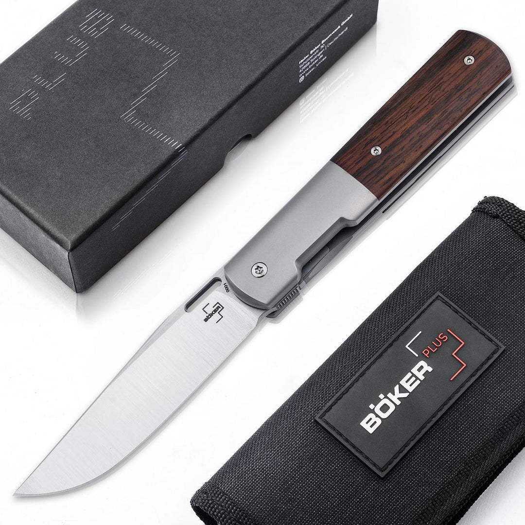 Boker Urban Barlow folding knife with cocobolo wood handle, titanium frame, and M390 steel blade, shown with box and pouch.