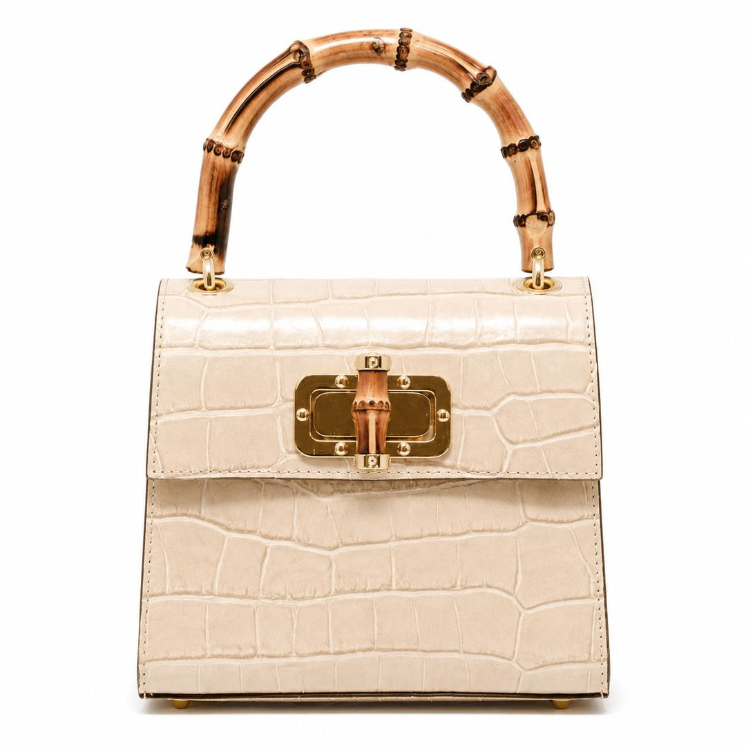 Cream-colored mini leather bag with a crocodile texture, gold hardware, and a distinctive arched bamboo handle.