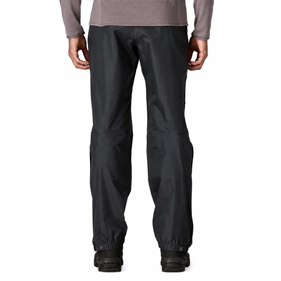 Back view of black Patagonia Torrentshell 3L waterproof rain pants with adjustable snap-tab cuffs and side zips.