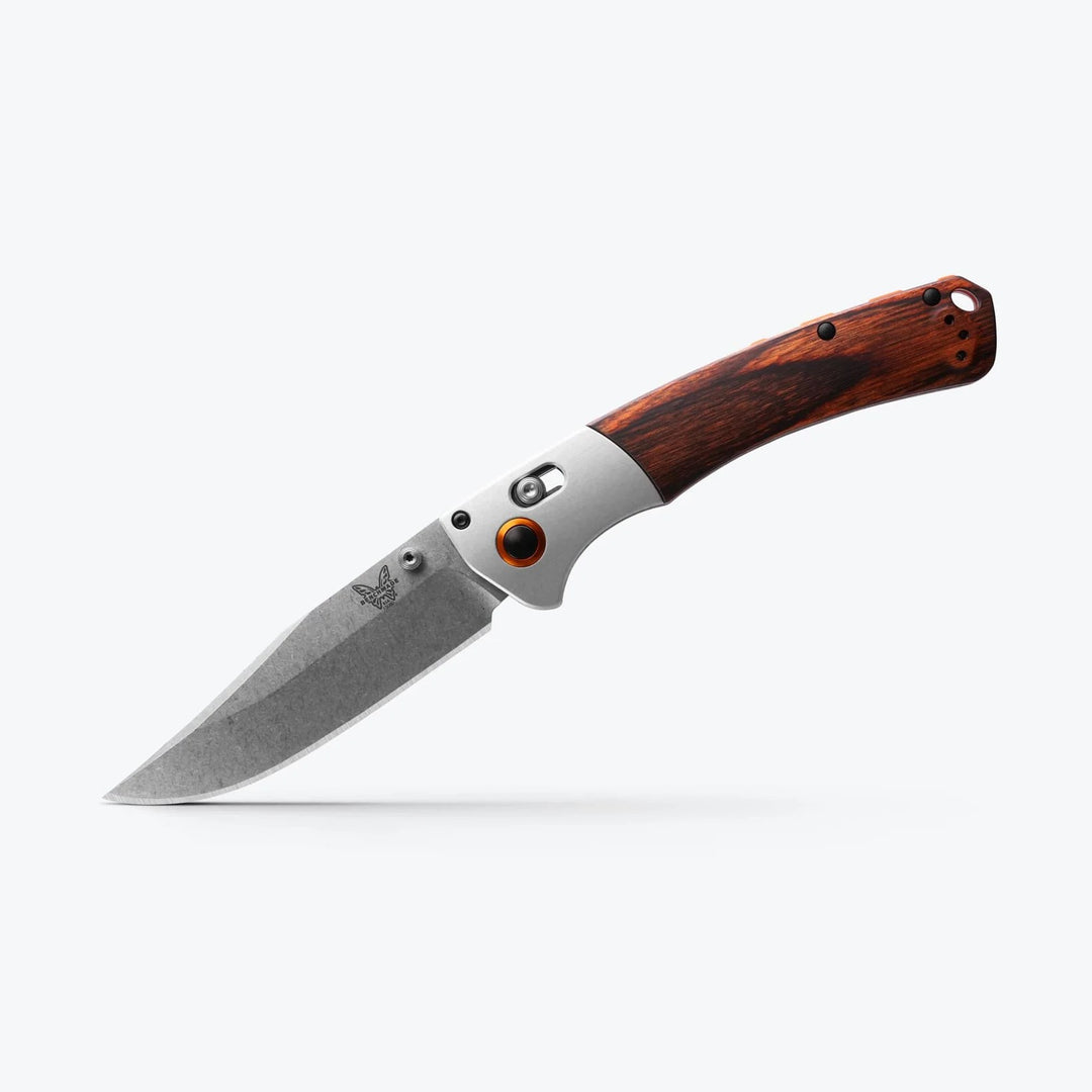 Benchmade Crooked River folding knife with a clip-point blade, wood handle, and signature orange pivot collar.