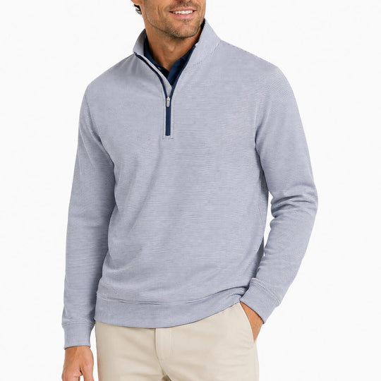 Man wearing a blue and white sugar stripe Peter Millar Perth performance quarter-zip pullover with a mock collar.