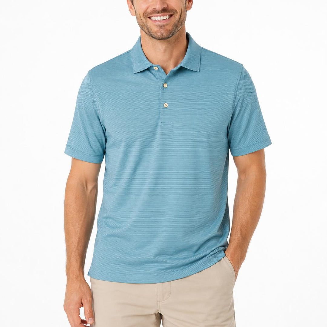Man wearing a blue Peter Millar performance jersey polo with a self-fabric collar and three-button placket.