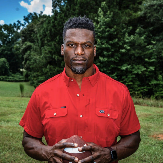 Man wearing a red University of Georgia performance shirt with magnetic chest pockets and a UGA logo outdoors.
