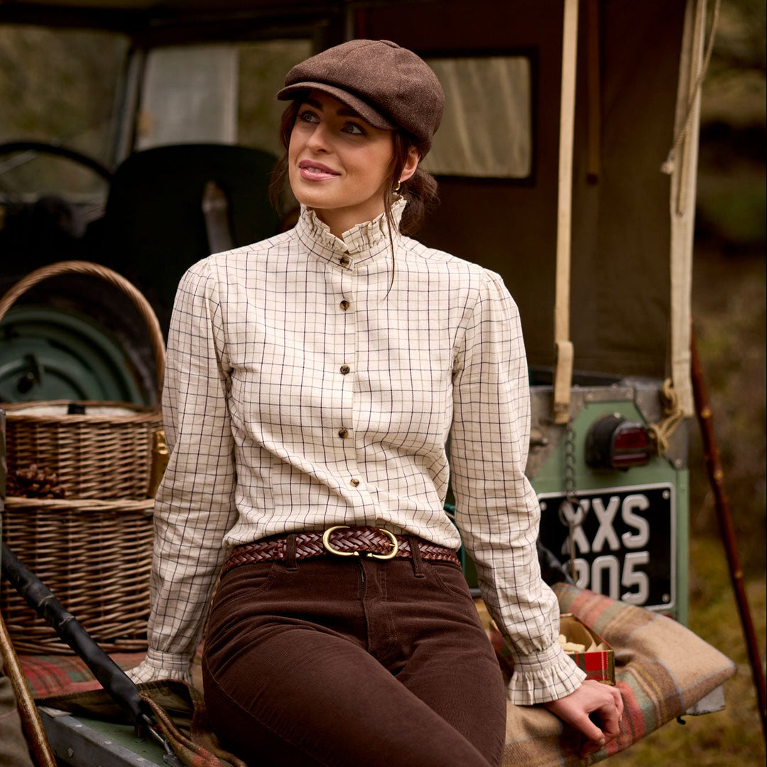 Woman wearing a cream check brushed cotton Sheringham shirt with a pie-crust collar and Schöffel branded buttons.