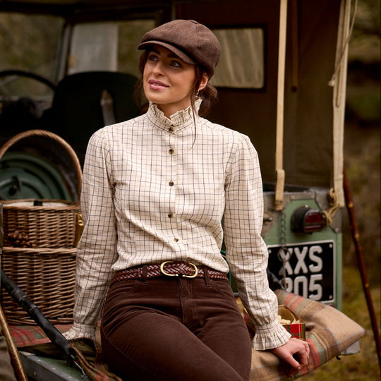 Woman wearing a cream check brushed cotton Sheringham shirt with a pie-crust collar and Schöffel branded buttons.