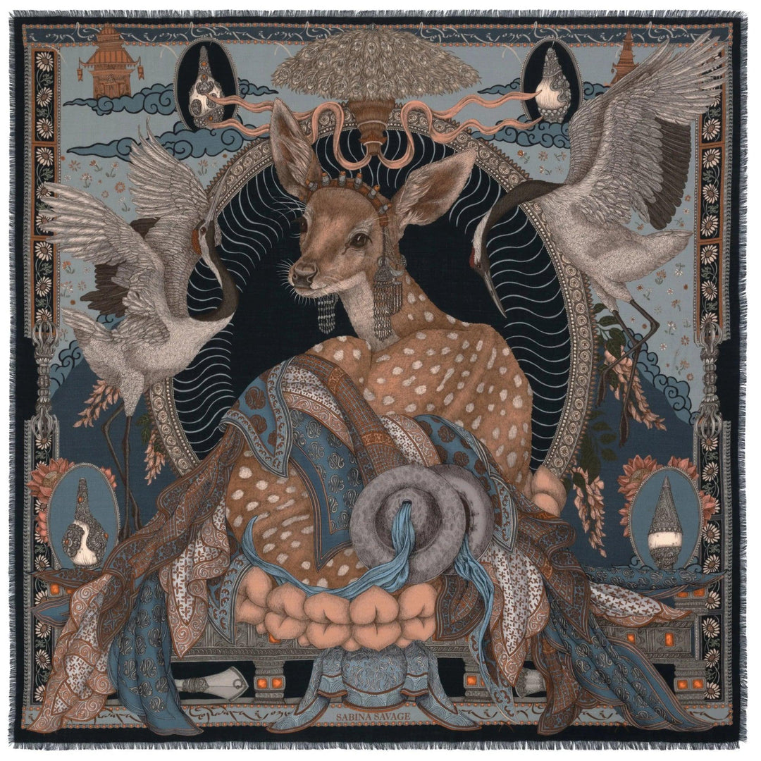 Sabina Savage wool-silk scarf featuring a deer in Tibetan jewelry, cranes, and lotus motifs on a blue and black background.