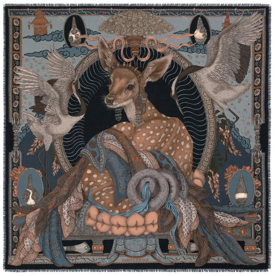 Sabina Savage wool-silk scarf featuring a deer in Tibetan jewelry, cranes, and lotus motifs on a blue and black background.