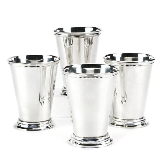 Set of four silver-plated brass mint julep cups with beaded rim and base detailing on a white background.