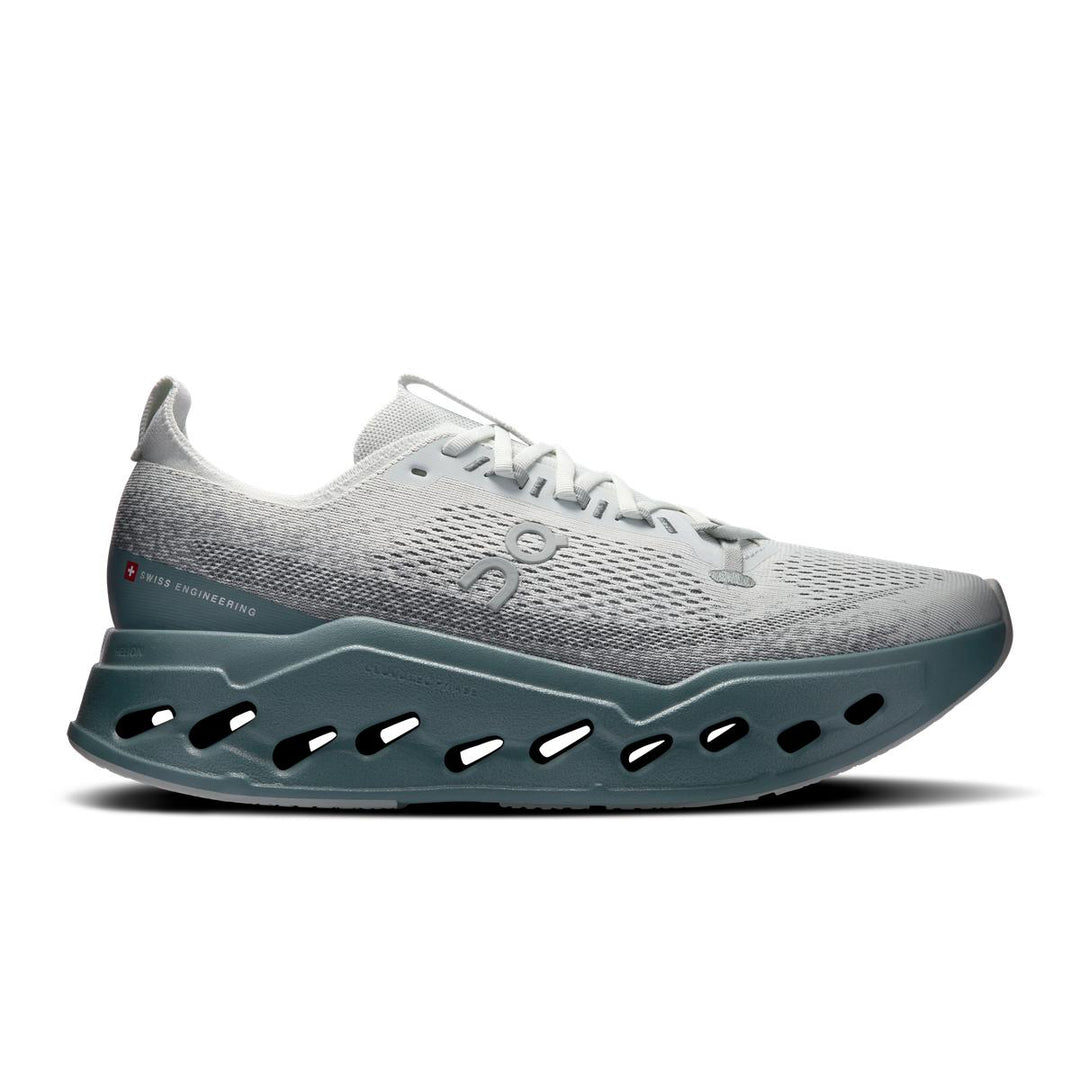 On Running Cloudsurfer Max in grey with a thick, teal CloudTec Phase cushioned sole and breathable mesh upper.