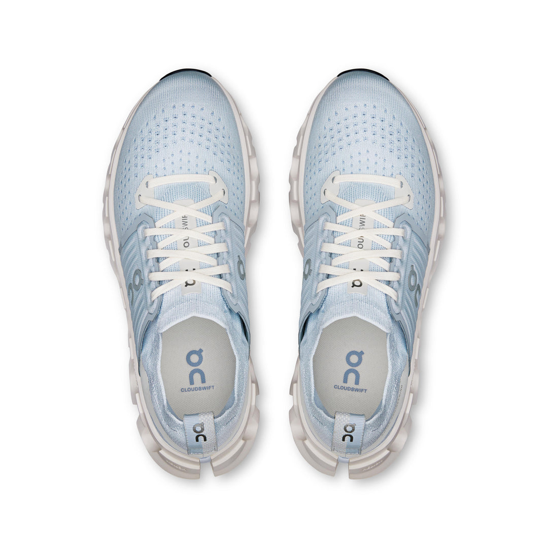 Top-down view of light blue On Running Cloudswift 4 women's sneakers with white laces and cushioned Helion foam midsoles.