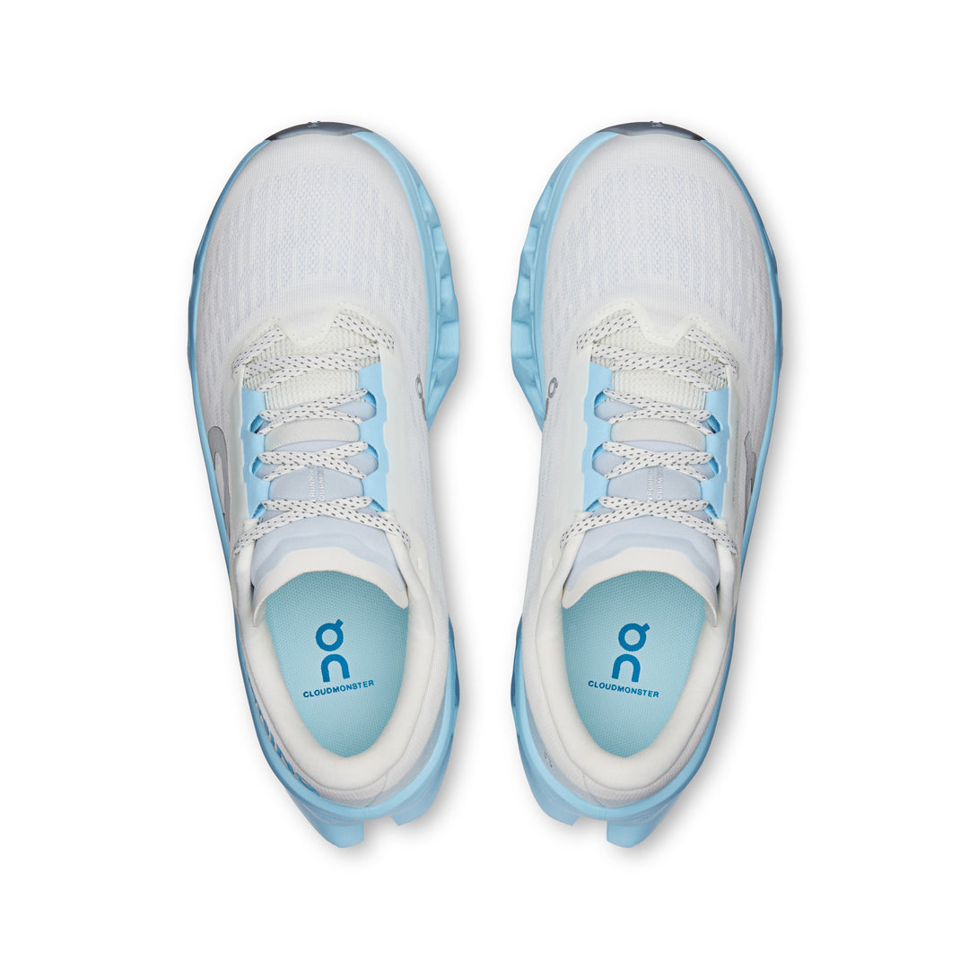 Top view of white and light blue On Cloudmonster 3 running shoes with breathable knit uppers and cushioned soles.