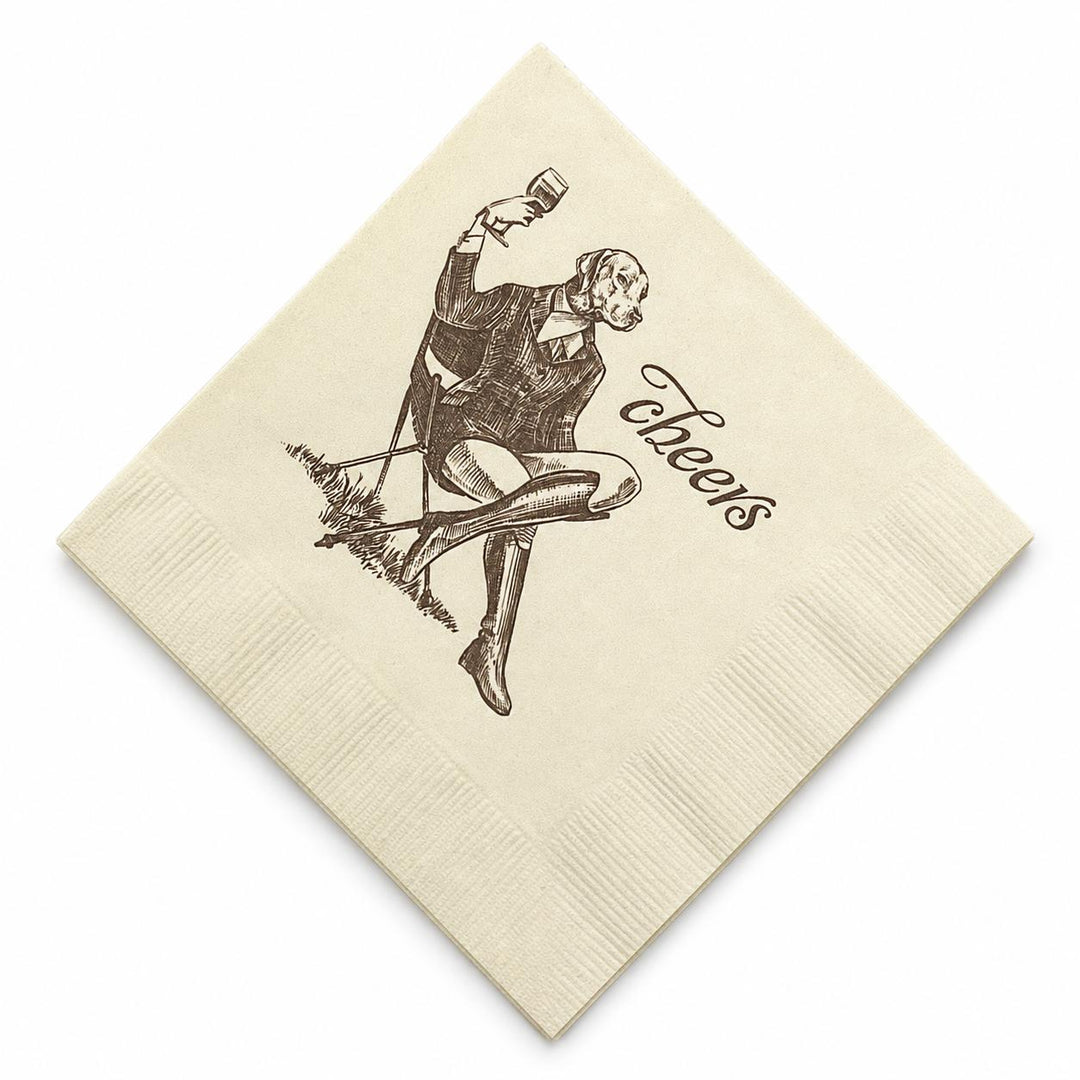 Cream-colored 5-inch 3-ply cocktail napkin featuring a brown ink illustration of a dog in a suit toasting with a glass.