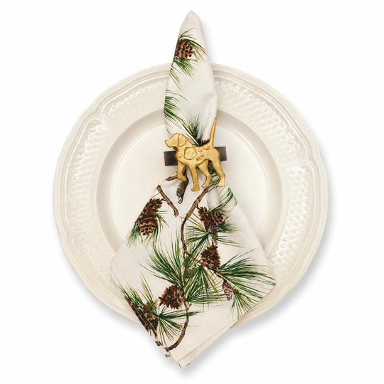 Soft cotton canvas napkin with bobwhite quail and longleaf pine print, held by a gold dog napkin ring on a white plate.
