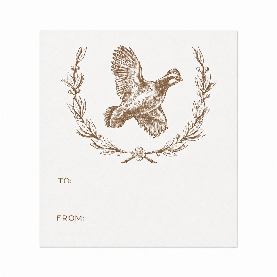 White paper gift sticker featuring a brown ink quail illustration inside a decorative wreath with To and From lines.