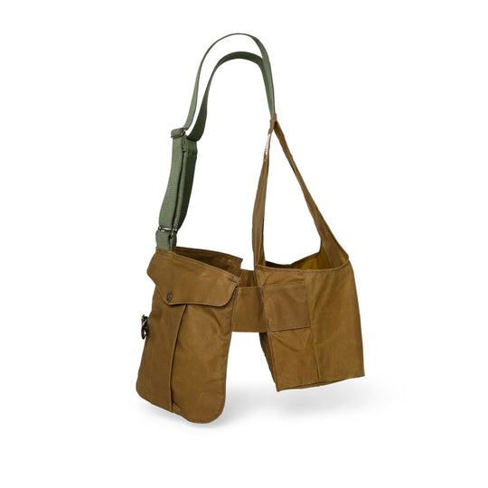 Tan Filson Tin Cloth game bag with green adjustable webbing straps and spacious shell pockets for hunting.