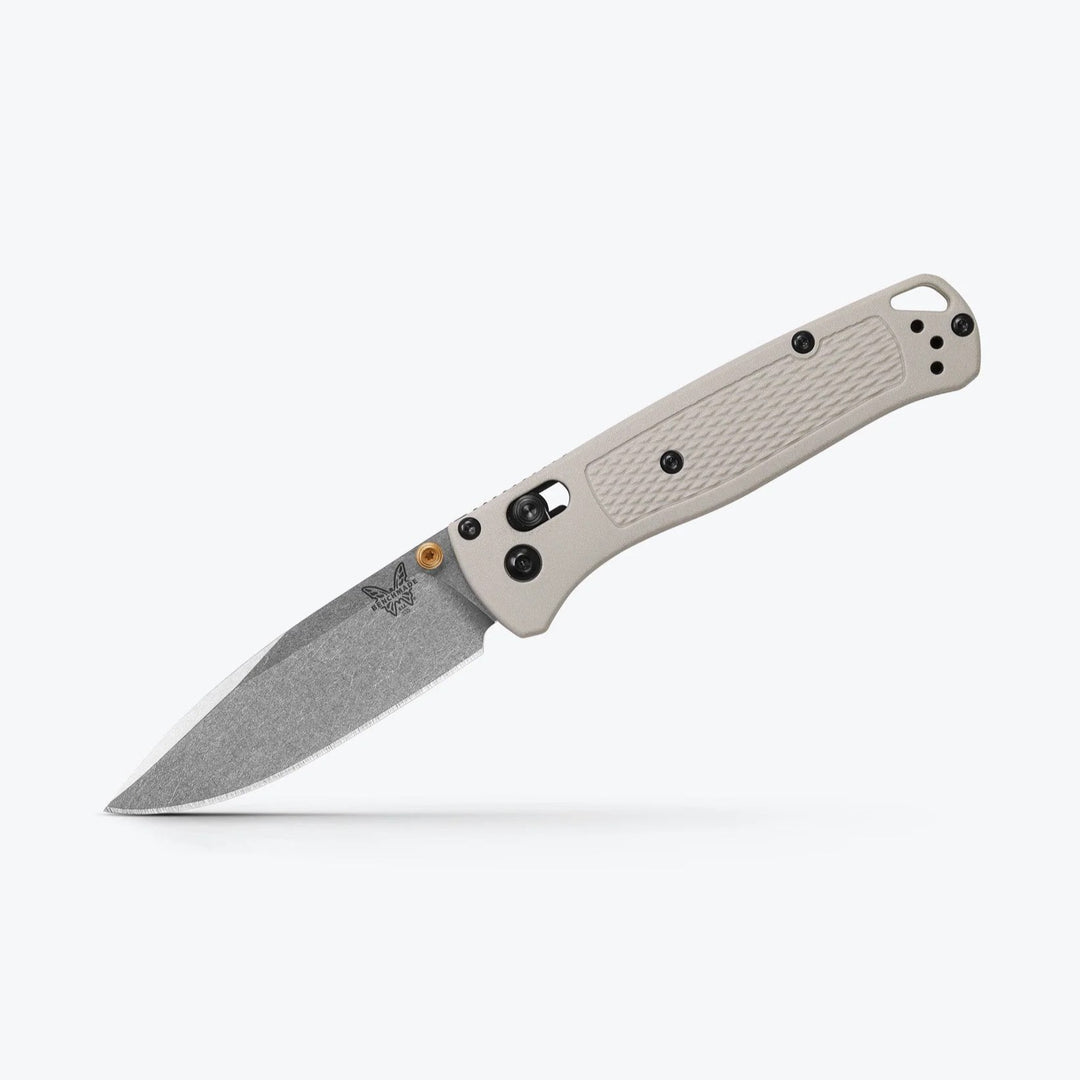 Benchmade Bugout folding knife with a grey textured handle, stonewashed drop-point blade, and gold-colored thumb stud.