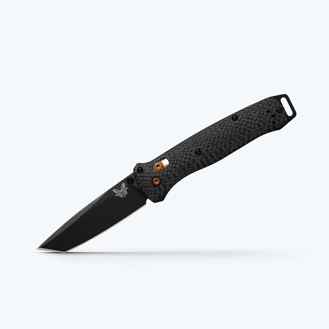 Benchmade Bailout folding knife with a black tanto blade, textured carbon fiber handle, and gold-colored thumb stud.