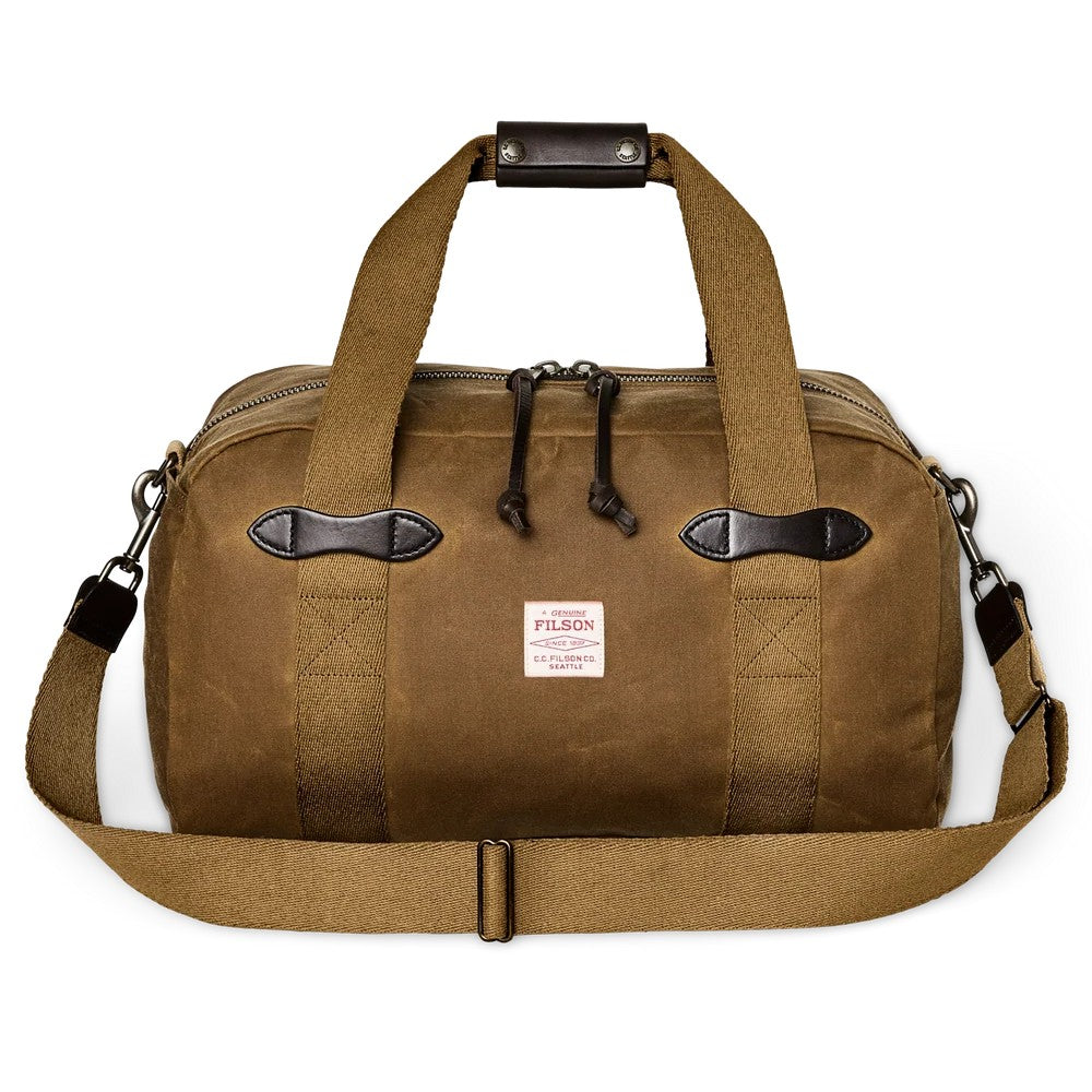 Tan Filson Tin Cloth small duffle bag with durable waxed cotton, leather carry grip, and sturdy webbing handles.