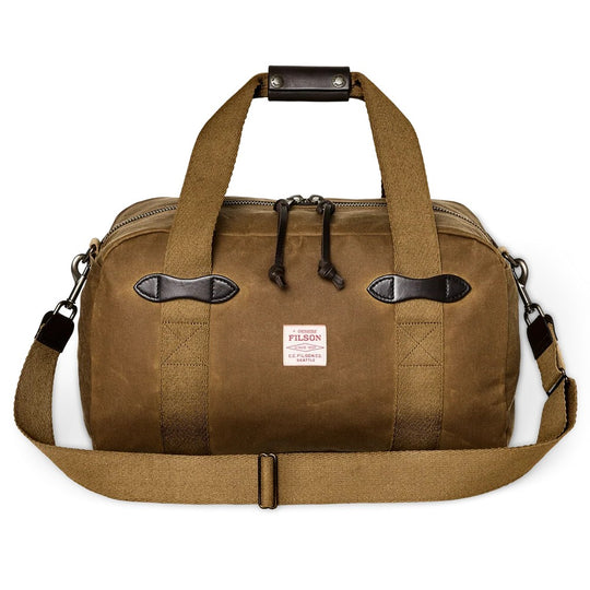Tan Filson Tin Cloth small duffle bag with durable waxed cotton, leather carry grip, and sturdy webbing handles.