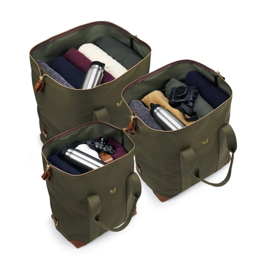 Three olive green Bennett Winch cargo bags in different sizes, featuring waterproof nylon, leather trim, and brass hardware.