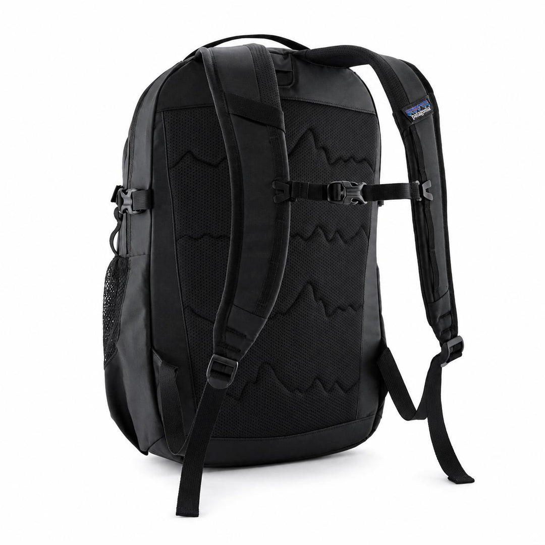 Black Patagonia Refugio 26L daypack showing the breathable mesh back panel, adjustable shoulder straps, and side pocket.