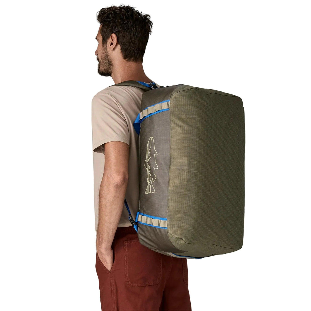 Man wearing an olive green Patagonia Black Hole 55L duffel bag with blue straps and a fish logo on his back.