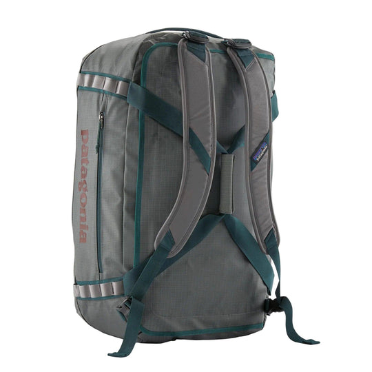 Grey Patagonia Black Hole 55L duffel bag with teal trim, padded shoulder straps, and reinforced daisy chains.