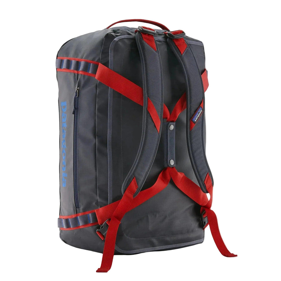 Patagonia Black Hole 55L duffel bag in dark grey with red shoulder straps and reinforced daisy chain gear loops.