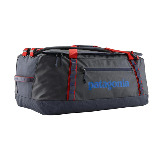 Charcoal grey Patagonia Black Hole 70L duffel bag with red straps, daisy chains, and a blue logo on a white background.