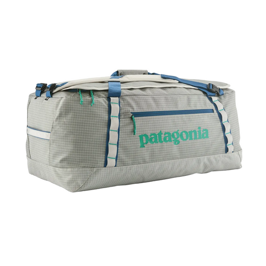 Patagonia Black Hole 70L duffel bag in grey grid pattern with blue straps, green logo, and daisy chain lash points.