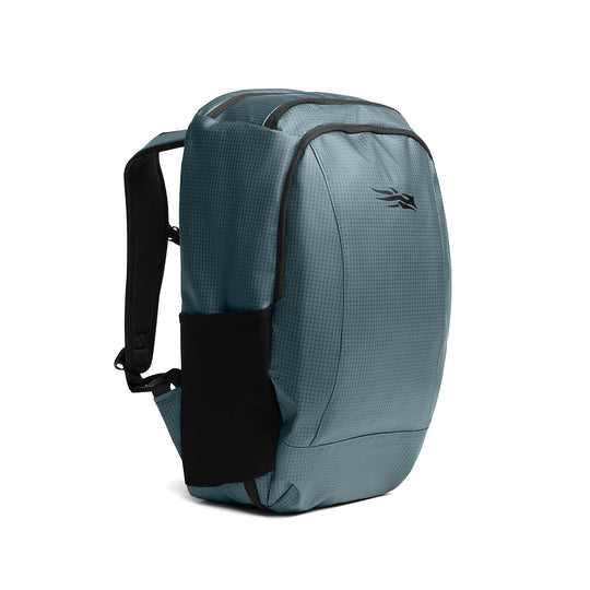 Blue-grey Sitka Drifter travel pack made of durable ripstop fabric with black mesh side pocket and padded straps.
