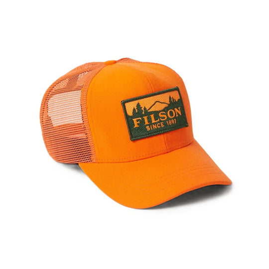 Bright orange Filson Logger mesh cap with a pre-curved bill and a rectangular embroidered patch featuring a forest scene.