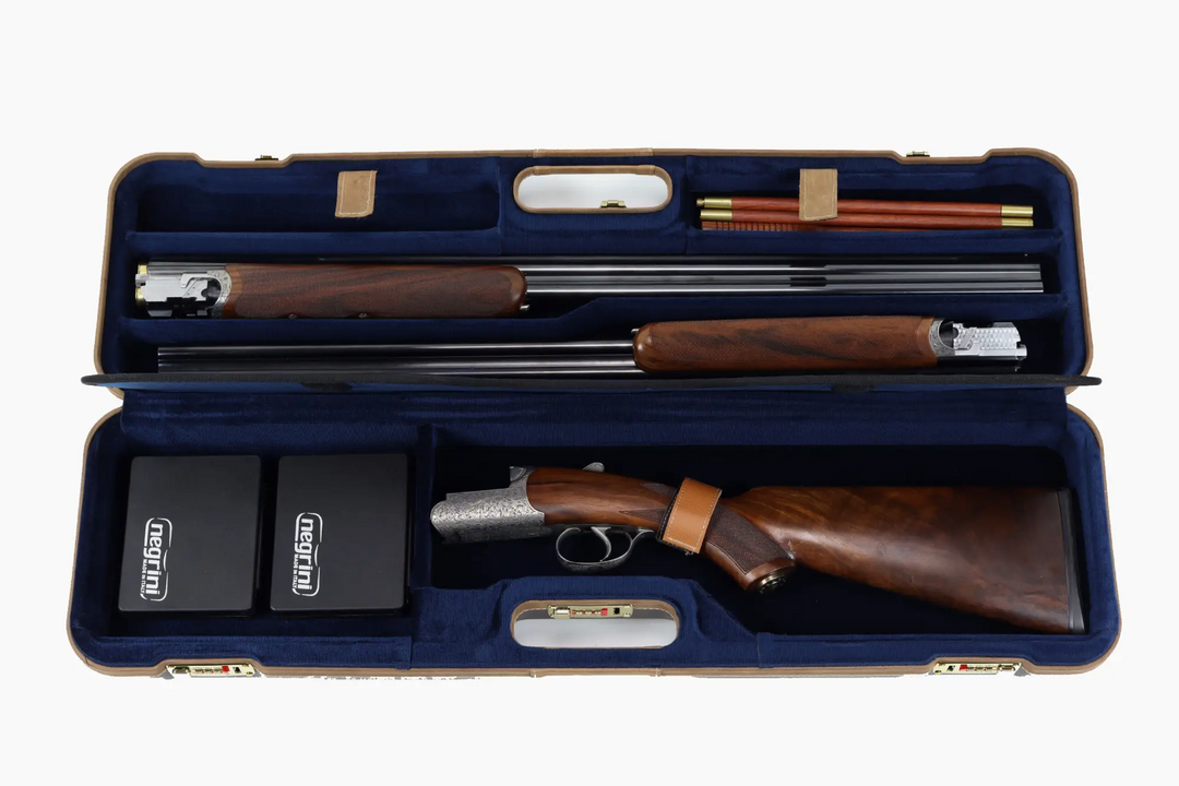 An open blue gun case displaying a shotgun with a brown wood-grain stock and barrel, along with accessories such as cleaning rods and two black boxes labeled 'GUN CARE'.