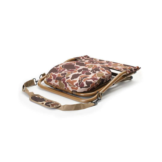 Rig 'Em Right Hyde Stool folded flat with a camo padded seat, brown metal frame, and adjustable shoulder strap.