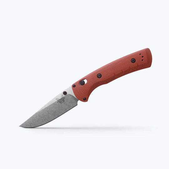 Folding knife with a red handle on a white background
