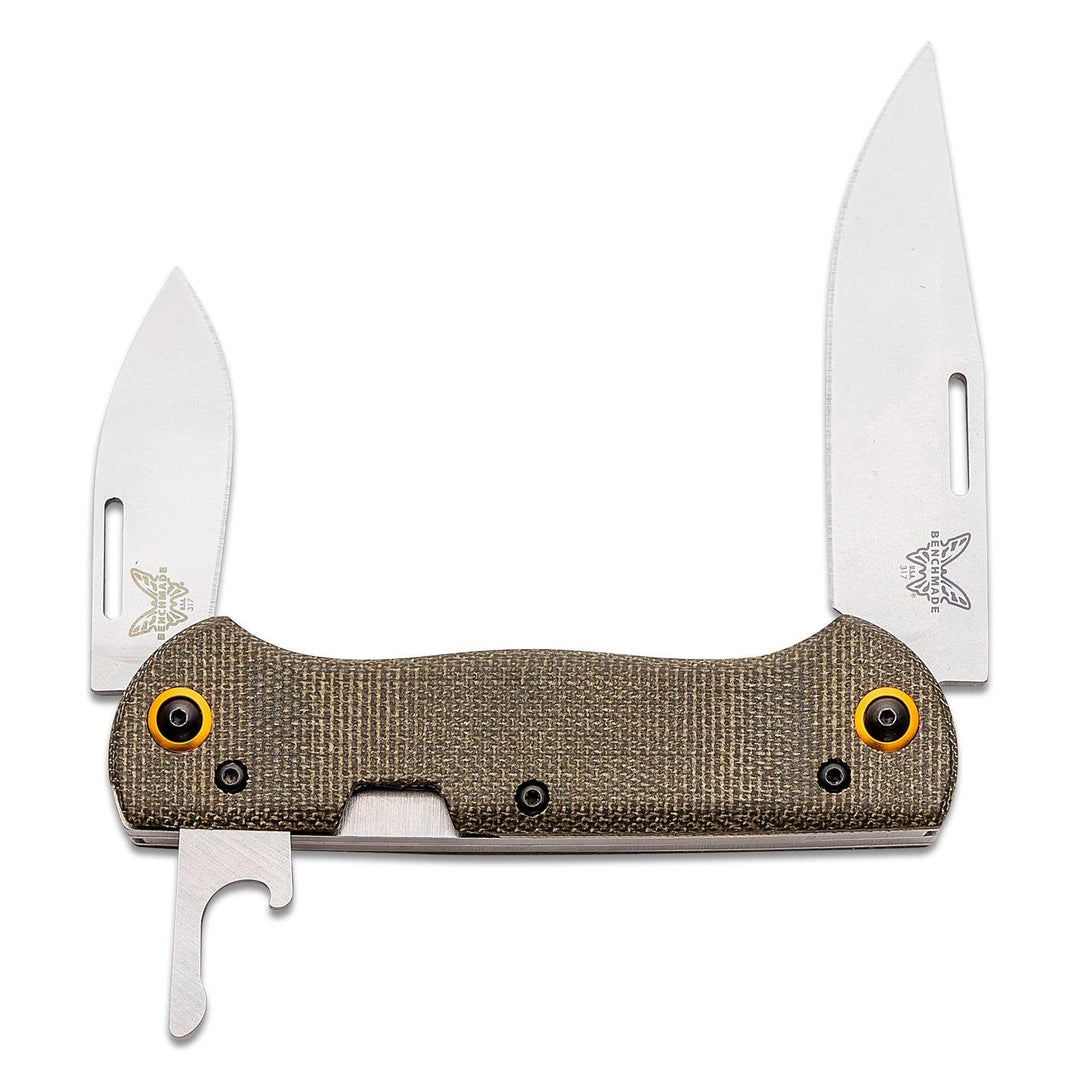 A folding pocket knife with two silver stainless steel blades fully extended, featuring a textured tan-brown G10 handle with bright orange accent screws and a silver bottle opener tool attached to the underside.