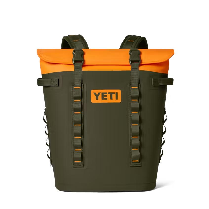 Olive green and orange YETI Hopper M20 backpack soft cooler with magnetic top closure and adjustable shoulder straps.