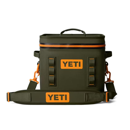 Olive green YETI Hopper Flip 12 soft cooler with a bright orange leakproof zipper, shoulder strap, and branded patches.